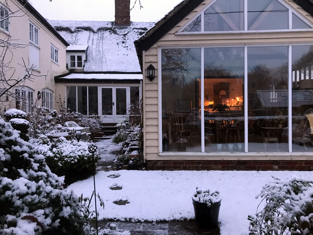 looking into the cosy house from the snowy garden